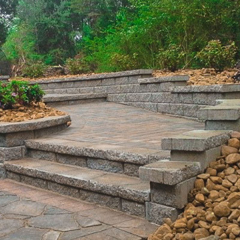 A stone walkway with stairs and a stone wall