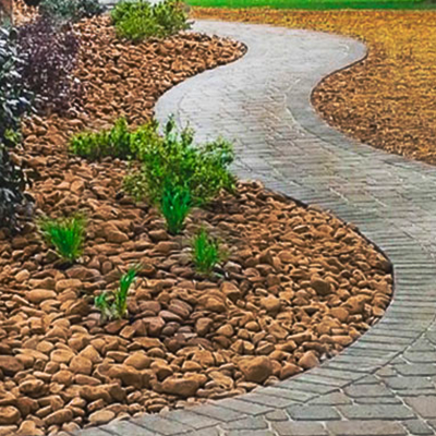 A curved walkway surrounded by rocks and plants