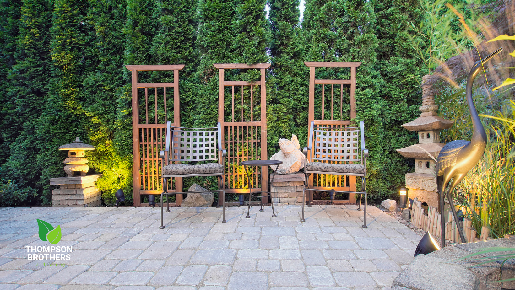 A patio with chairs , a table and a lantern.