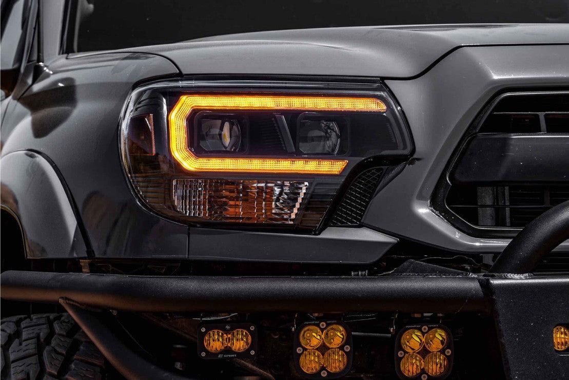 A close up of the front of a toyota tacoma with led headlights.