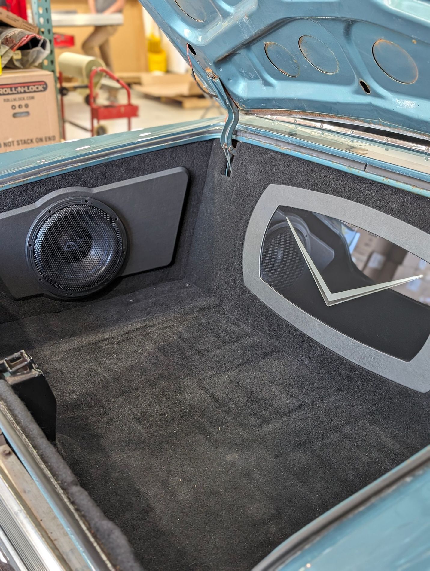 The trunk of a car with a speaker in it