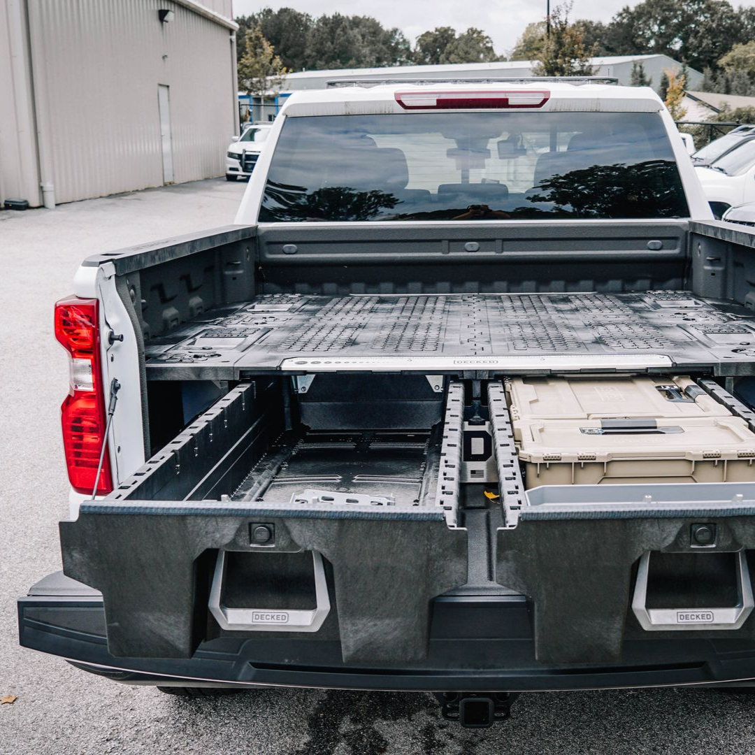 White pickup truck with bed storage system; open drawers reveal storage bins.