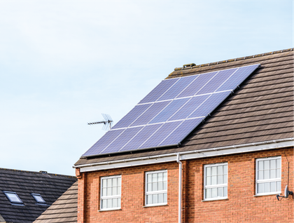 A brick house with solar panels on the roof.