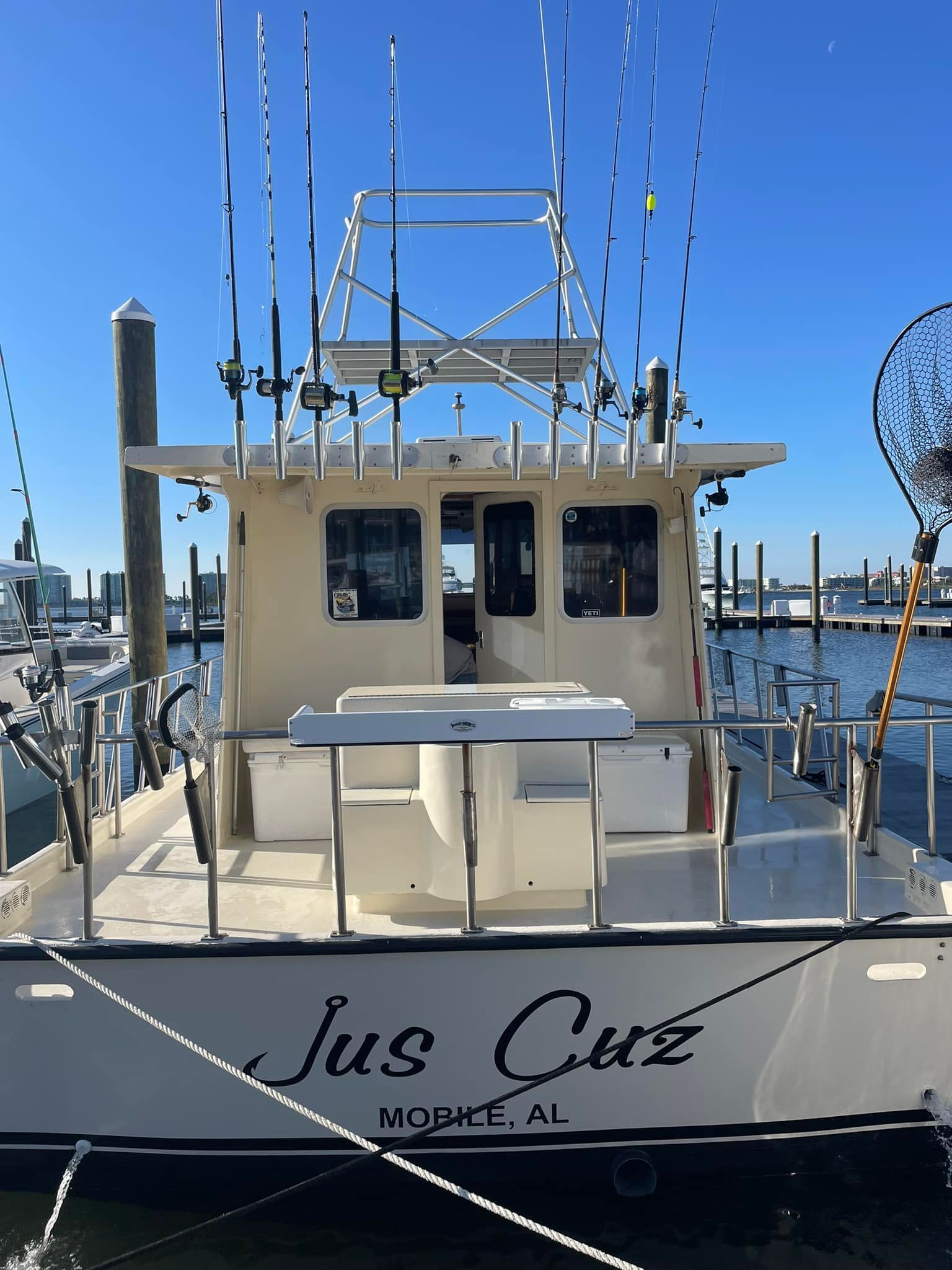 A boat with the name jus cue on the back