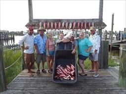 A group of people are posing for a picture on a dock.
