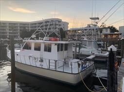 A boat is docked in a marina next to a building.