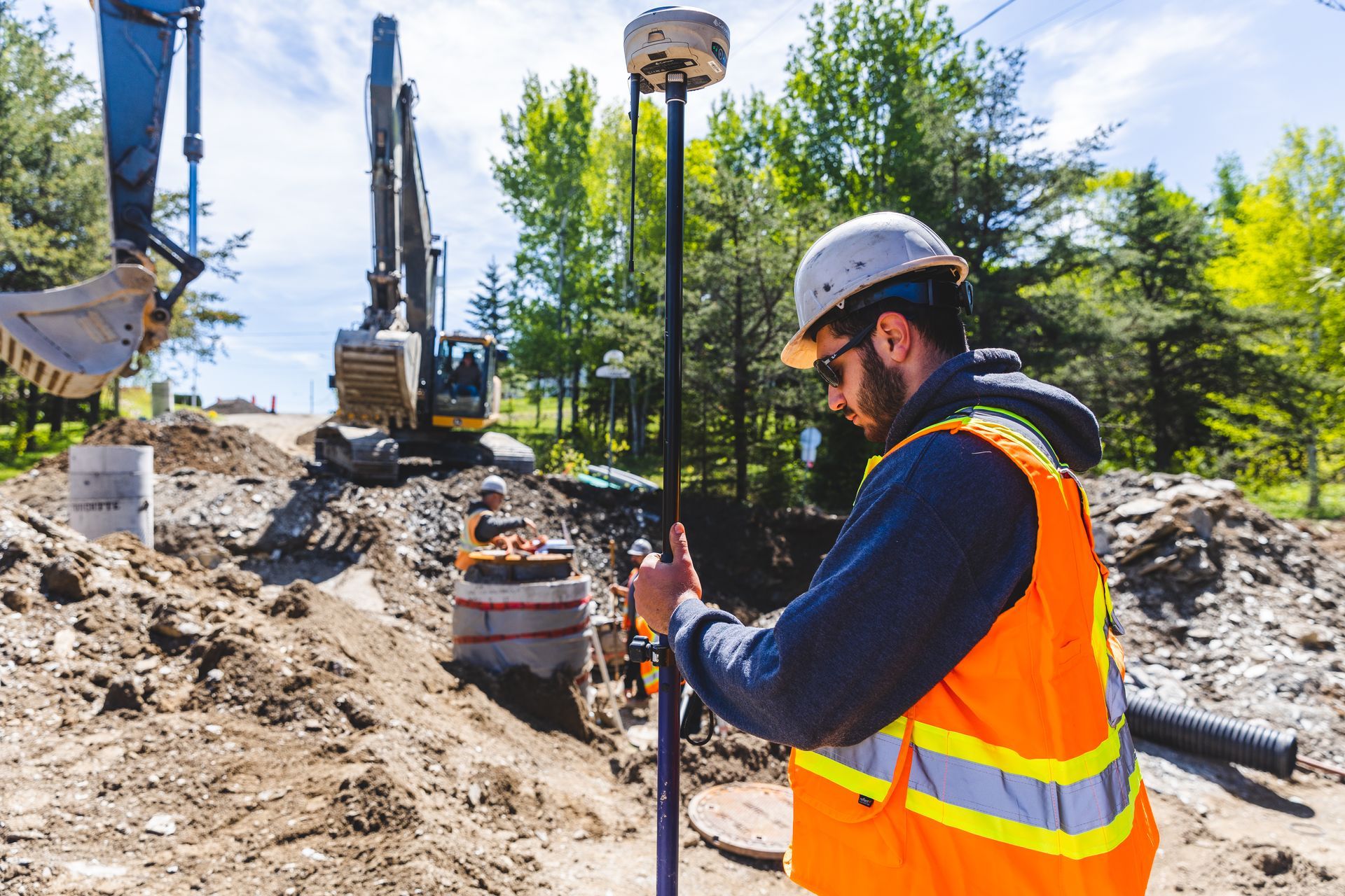 Un ouvrier du bâtiment utilise un appareil GPS sur un chantier de construction.