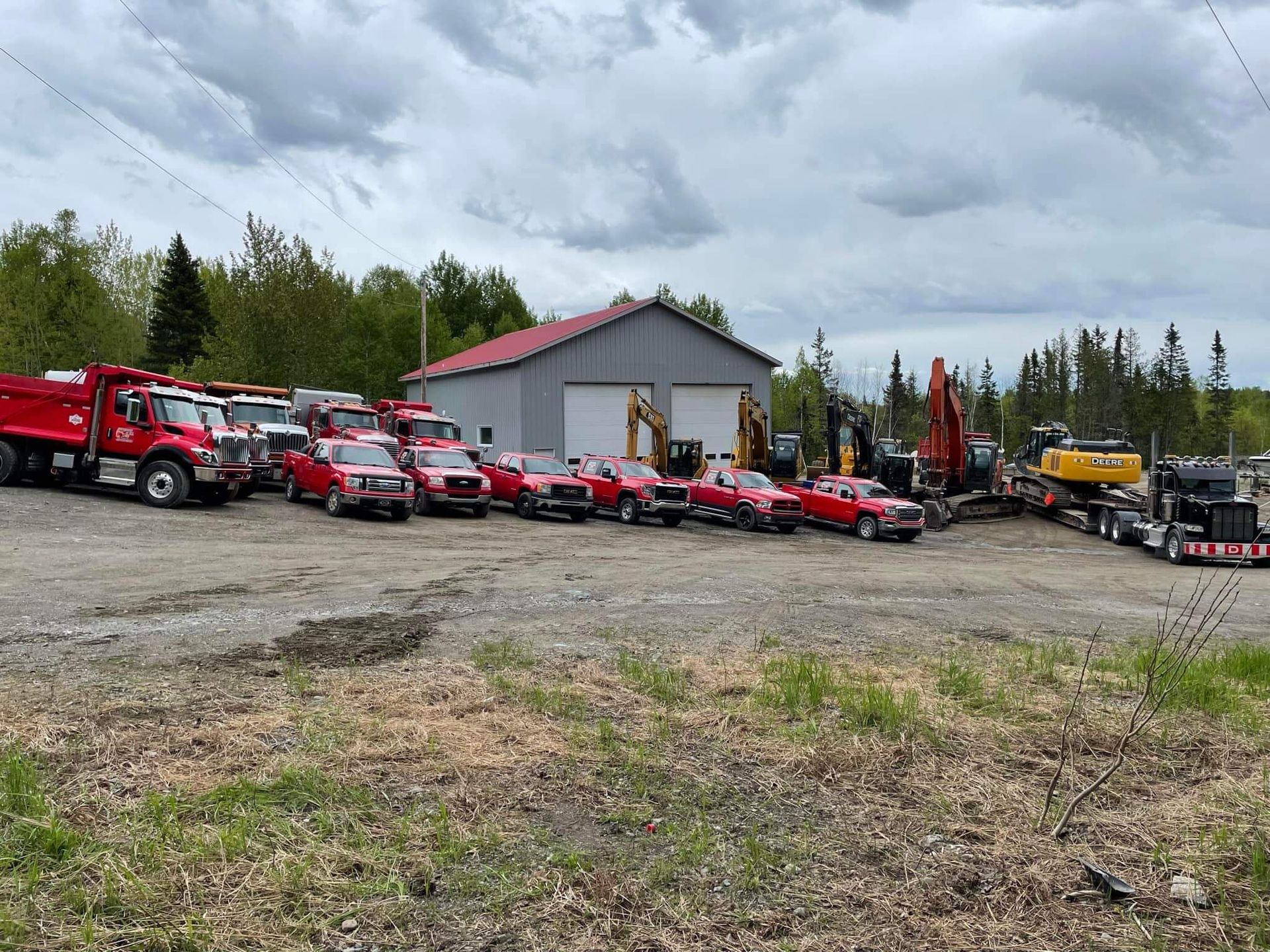 Une rangée de camions rouges sont garés devant un immeuble.
