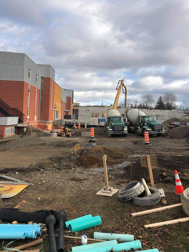 Un chantier de construction avec beaucoup de tuyaux et de camions.