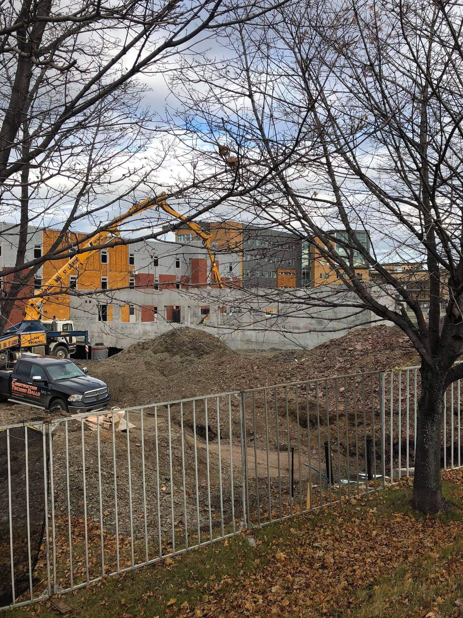 Une voiture est garée devant un immeuble en construction.