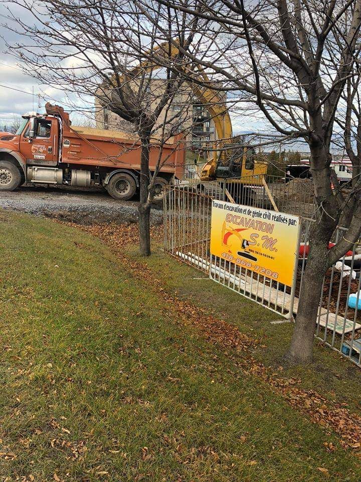 Un camion-benne est garé devant un chantier de construction.