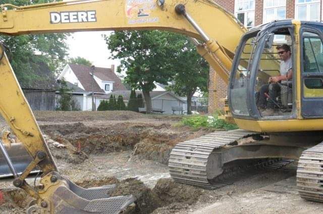 Une excavatrice Deere creuse un trou dans le sol