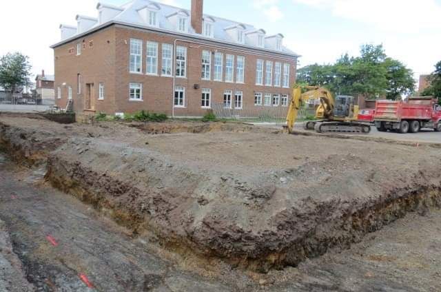 Un chantier de construction avec un grand bâtiment en brique en arrière-plan