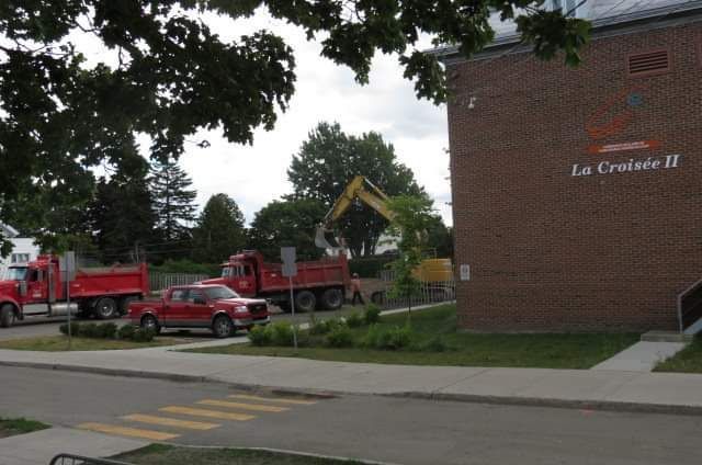 Un camion benne est garé devant un immeuble qui dit la croisiere ii
