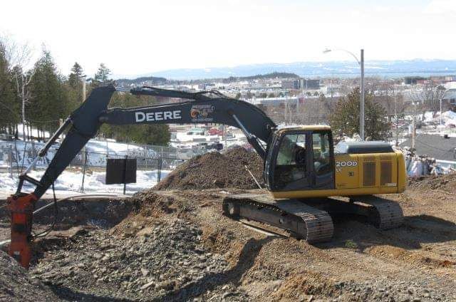 Une excavatrice de cerf jaune creuse un trou dans la terre