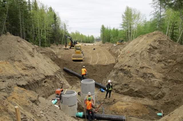 Un groupe d'ouvriers du bâtiment travaillent sur une route.