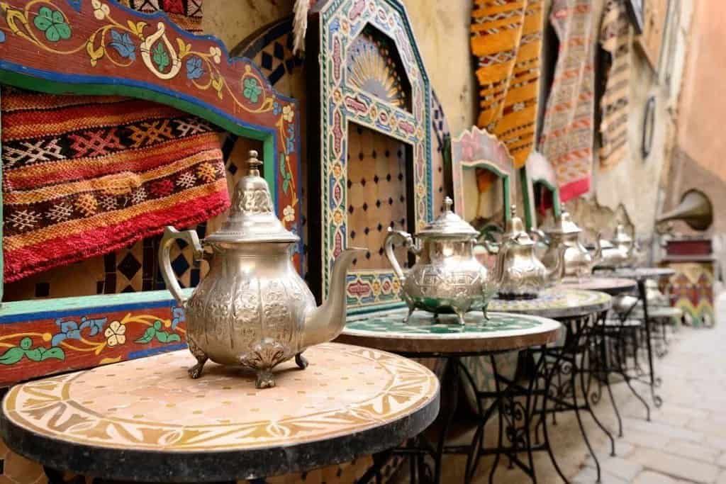 A teapot is sitting on top of a table in front of a row of tables.