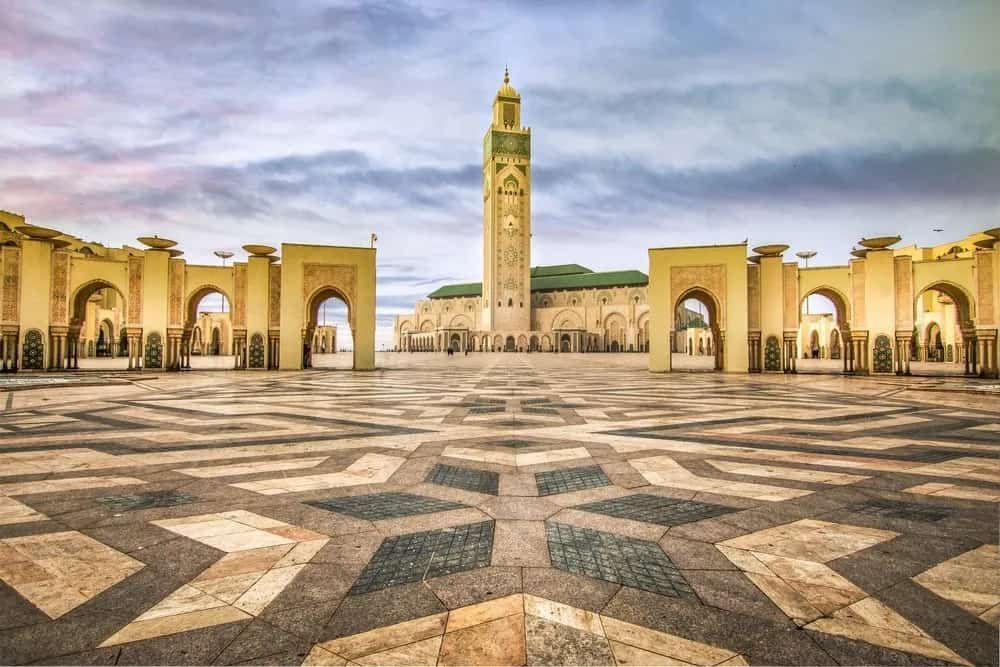 A large mosque with a clock tower in the middle of a square.