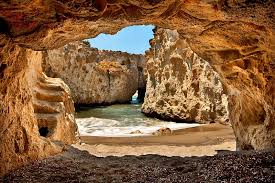 A view of a beach from inside a cave.