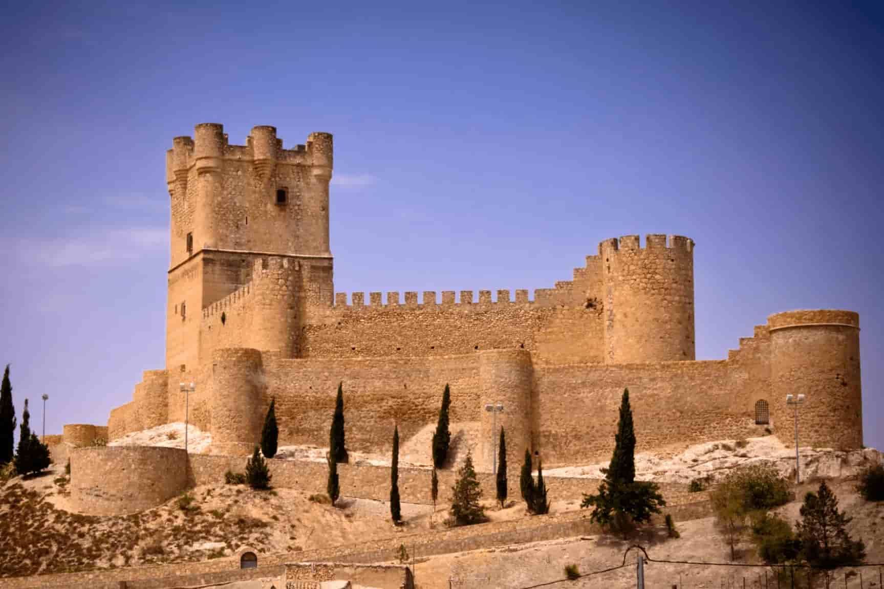 A large stone castle is sitting on top of a hill in Alicante.