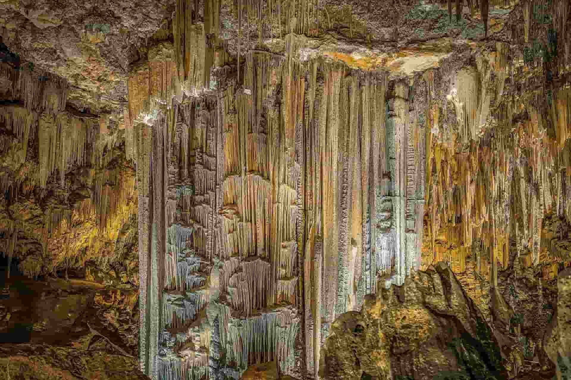 A cave with a lot of rocks and icicles hanging from the ceiling.