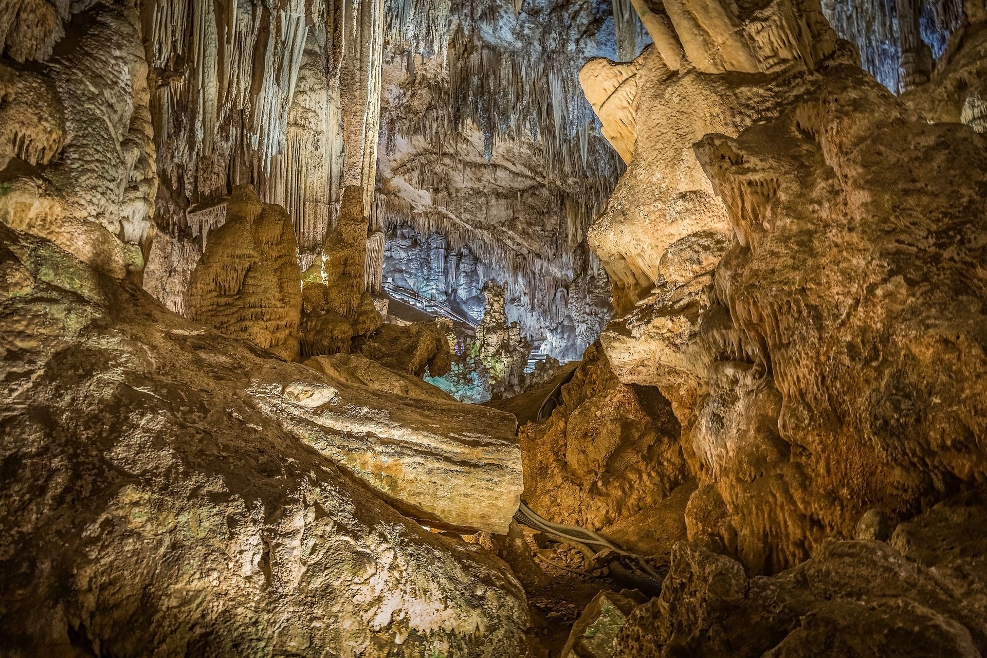 A cave with a lot of rocks and icicles hanging from the ceiling.