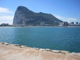 Gibraltar is sitting on top of a body of water next to a city.