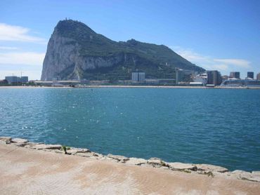 Gibraltar is sitting on top of a body of water next to a city.