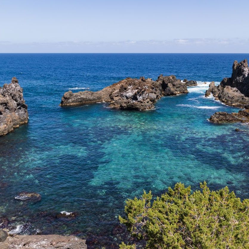 A large body of water surrounded by rocks and trees