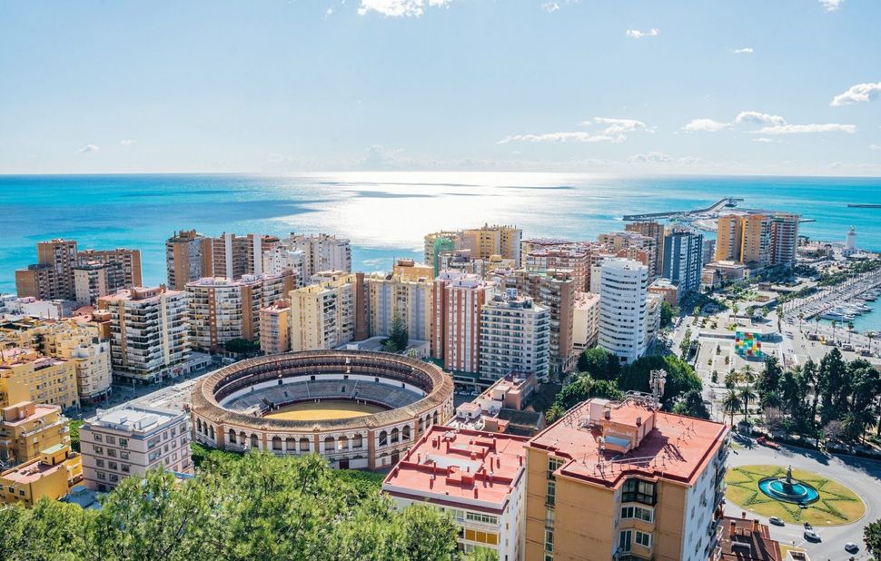 An aerial view of a malaga with a bullring in the middle of it.