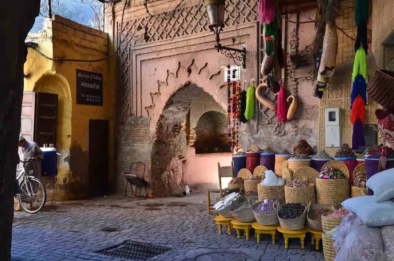A man is riding a bike down a cobblestone street in Marrakesh.