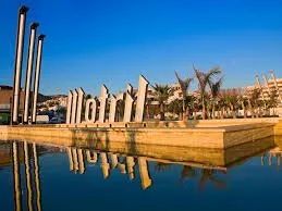 There is a reflection of a statue in the waterin Motril port