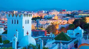 An aerial view of Tangier at night with a white building in the foreground.