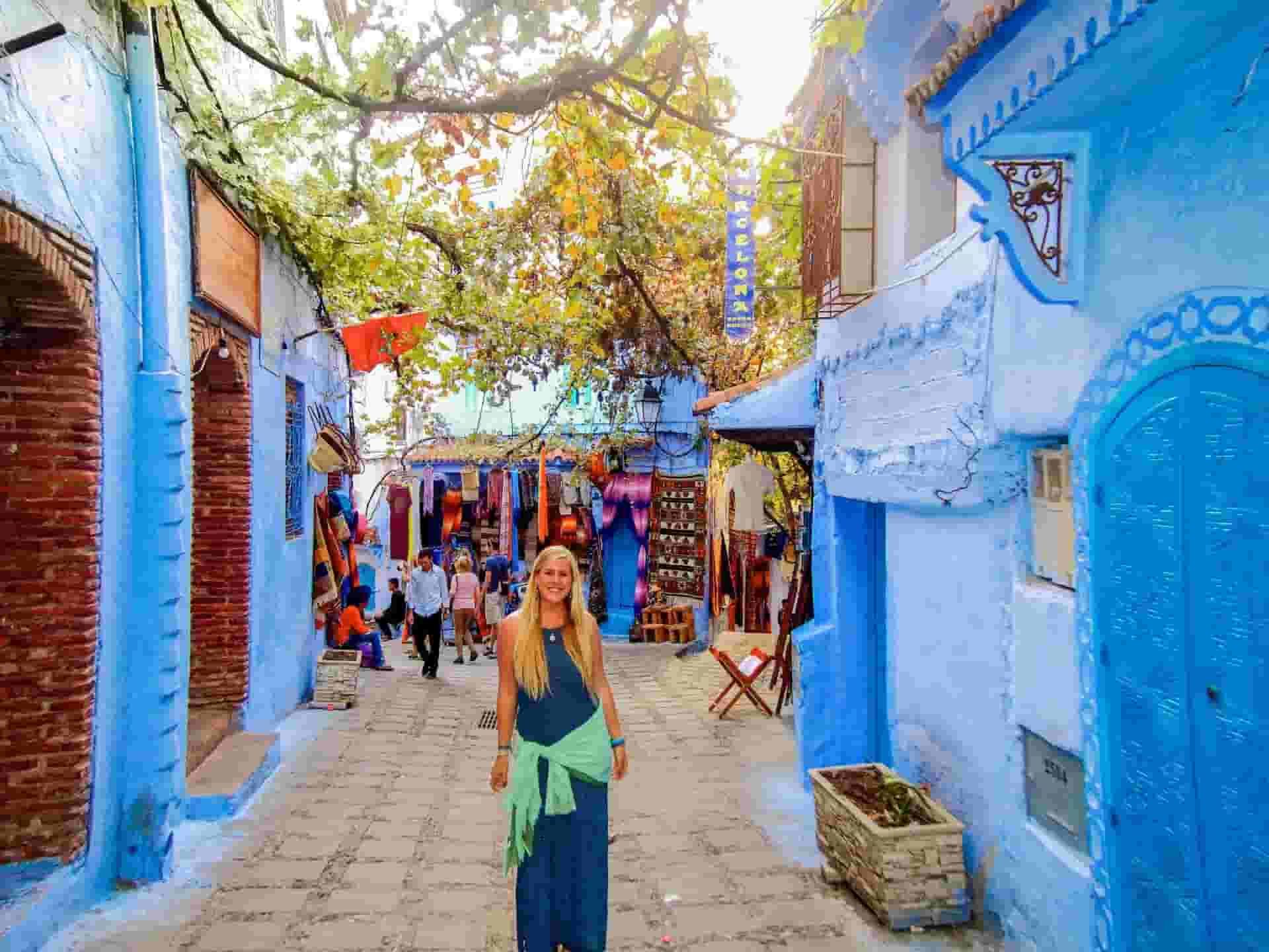 A blue building with a pretty girl in the street