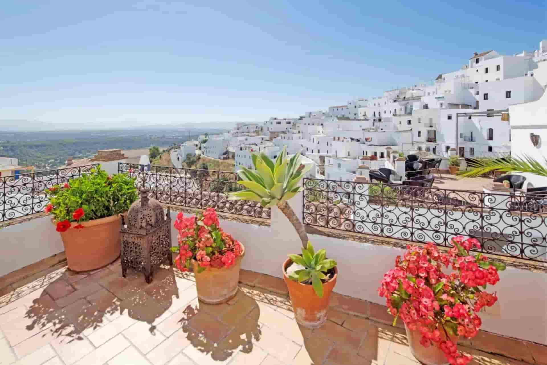 A balcony with potted plants and a view of a city
