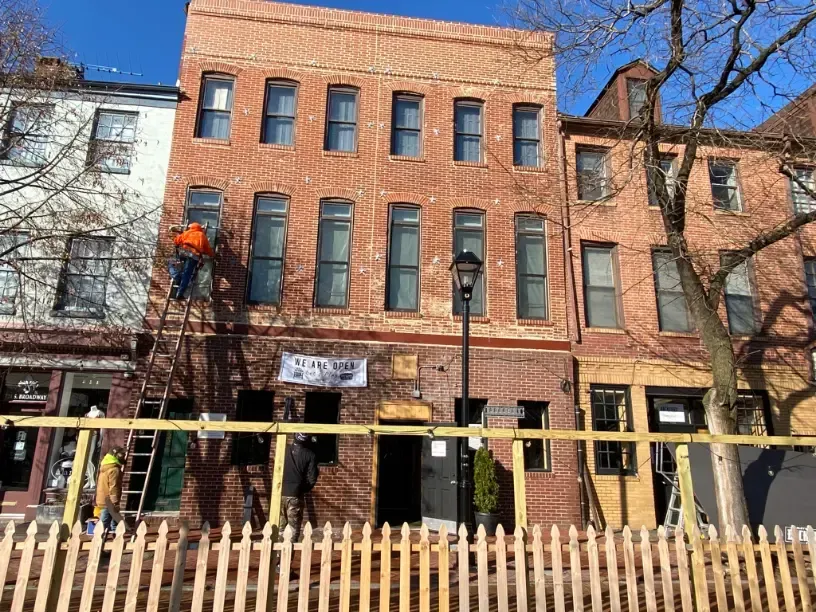 A brick building with a wooden fence in front of it