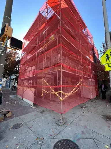 Building envelope repair project with scaffolding and netting