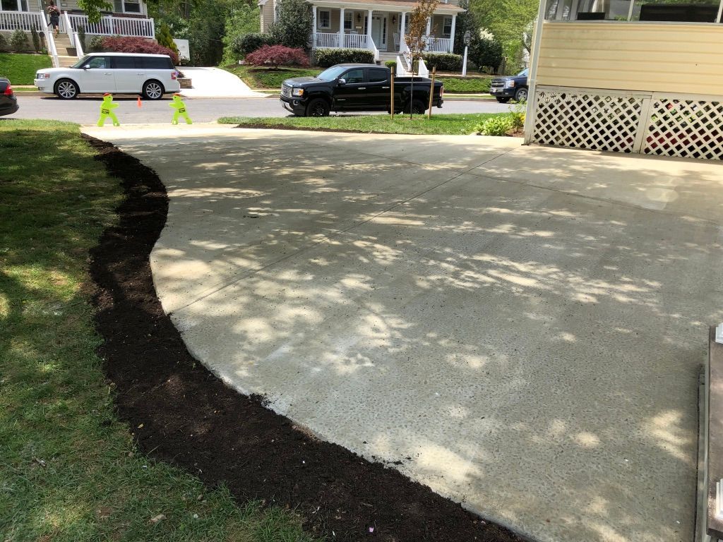 A car is parked in a driveway next to a house.