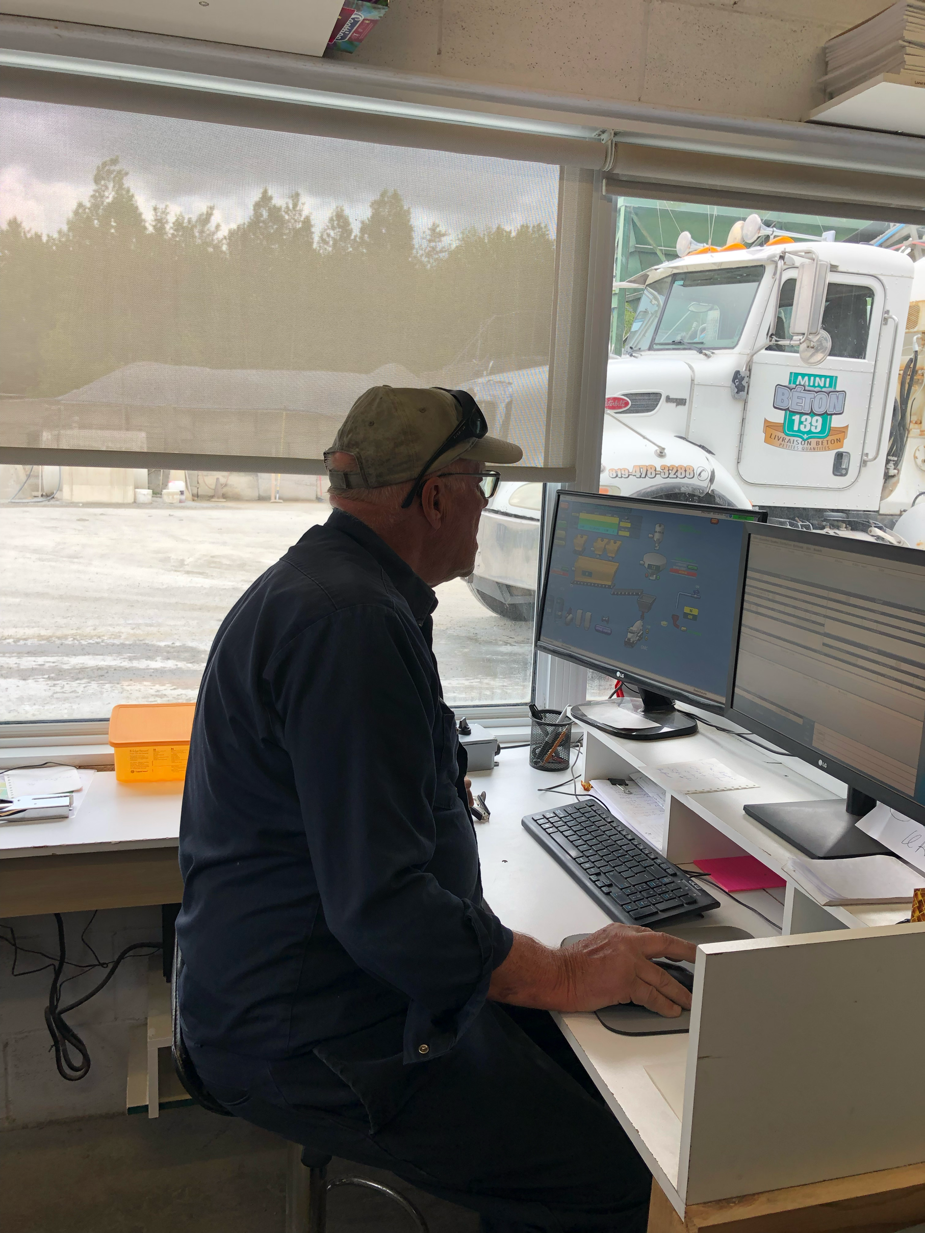 Un homme est assis à un bureau devant un ordinateur.