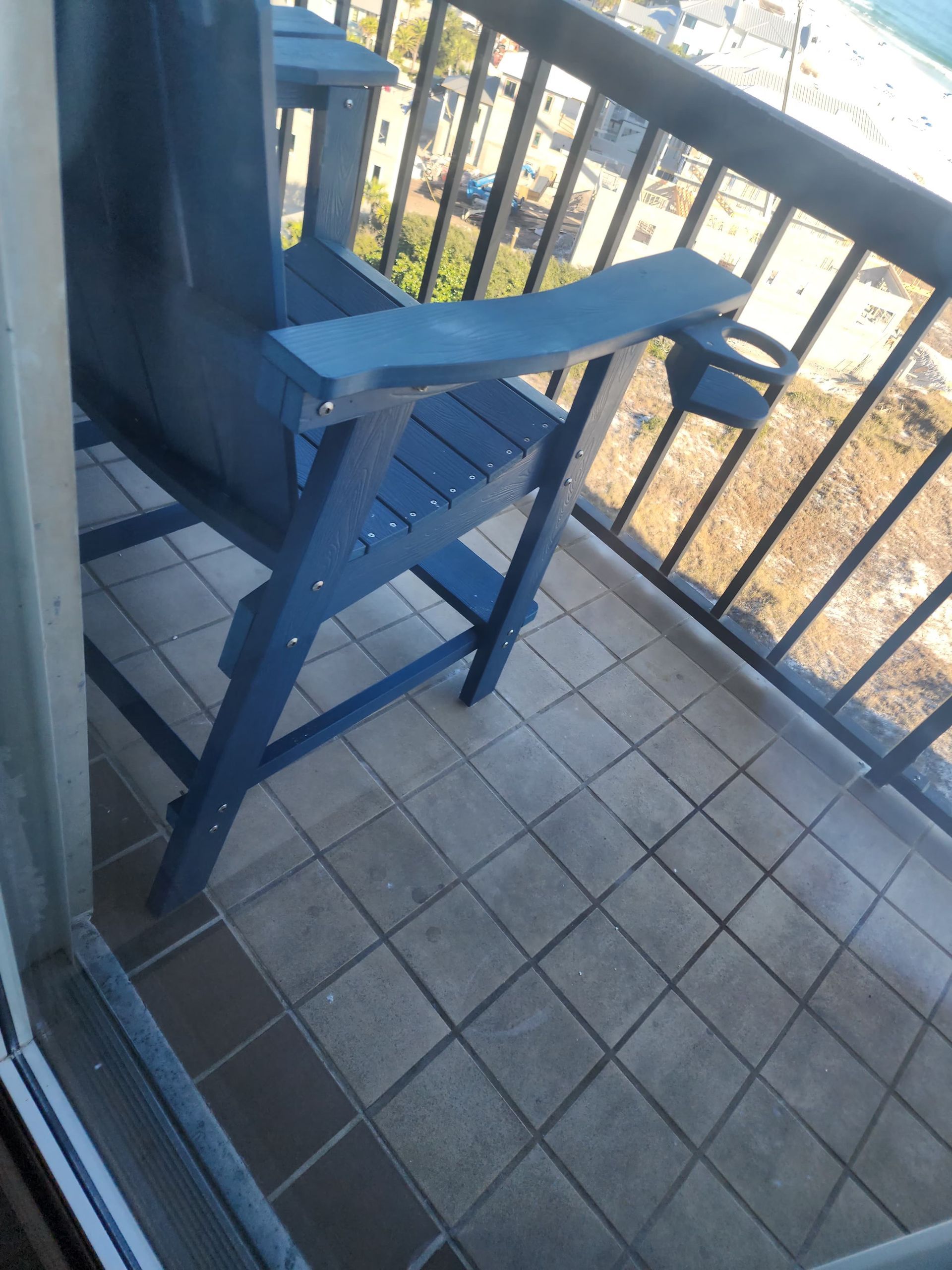 Blue Adirondack chair on a balcony with a view.