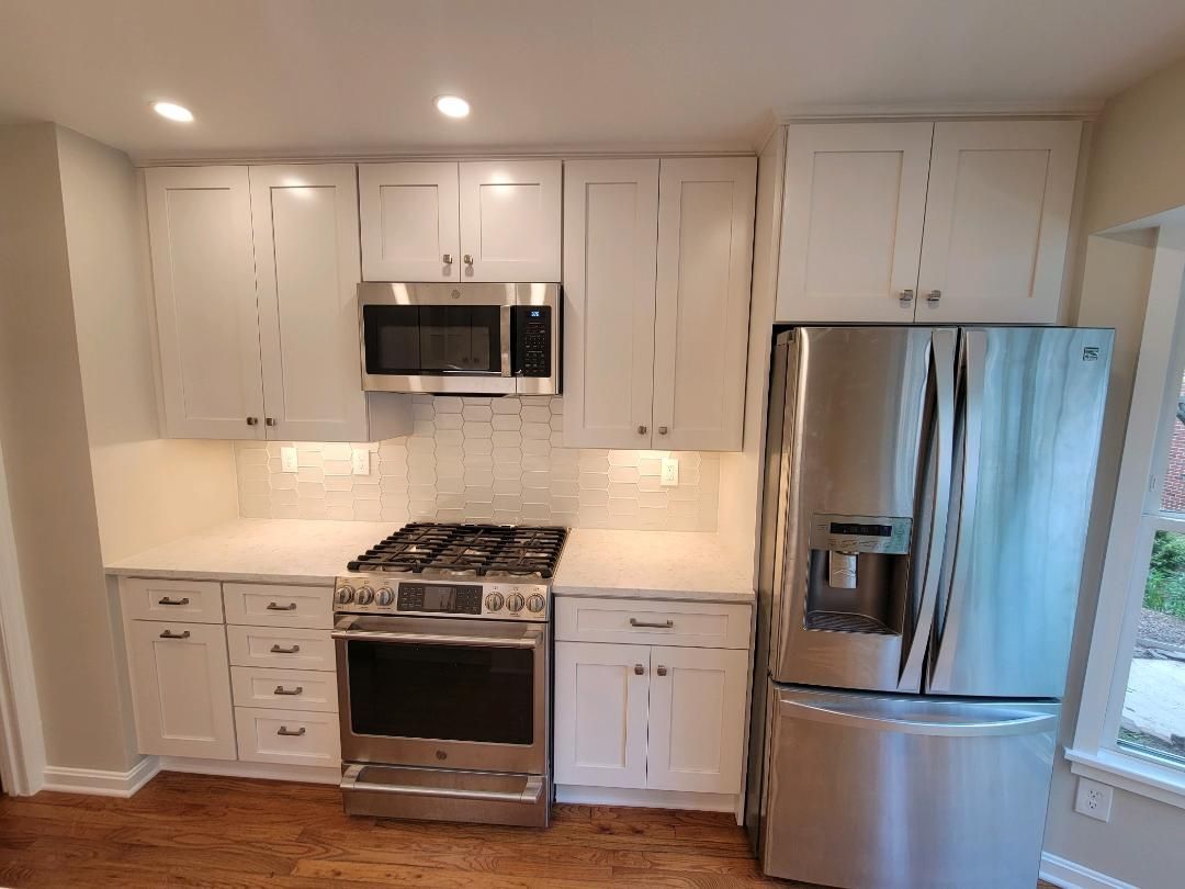 White kitchen with stainless steel appliances and white cabinets.
