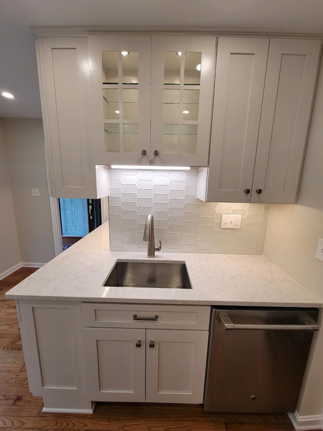 White kitchen cabinets with a sink and dishwasher.
