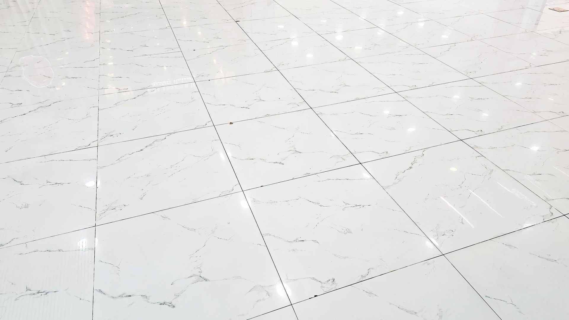 A close up of a white tiled floor with a checkered pattern.