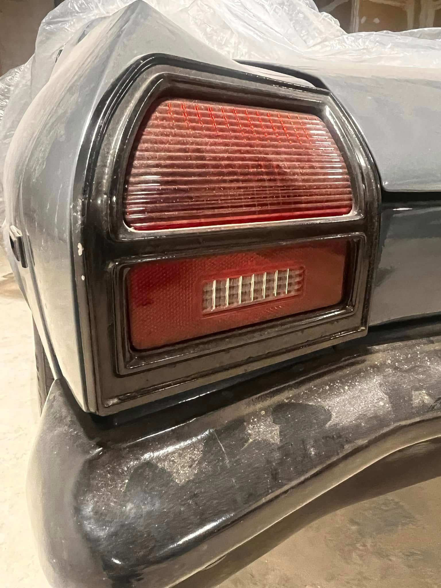 Black car taillight with a red lens and black trim.