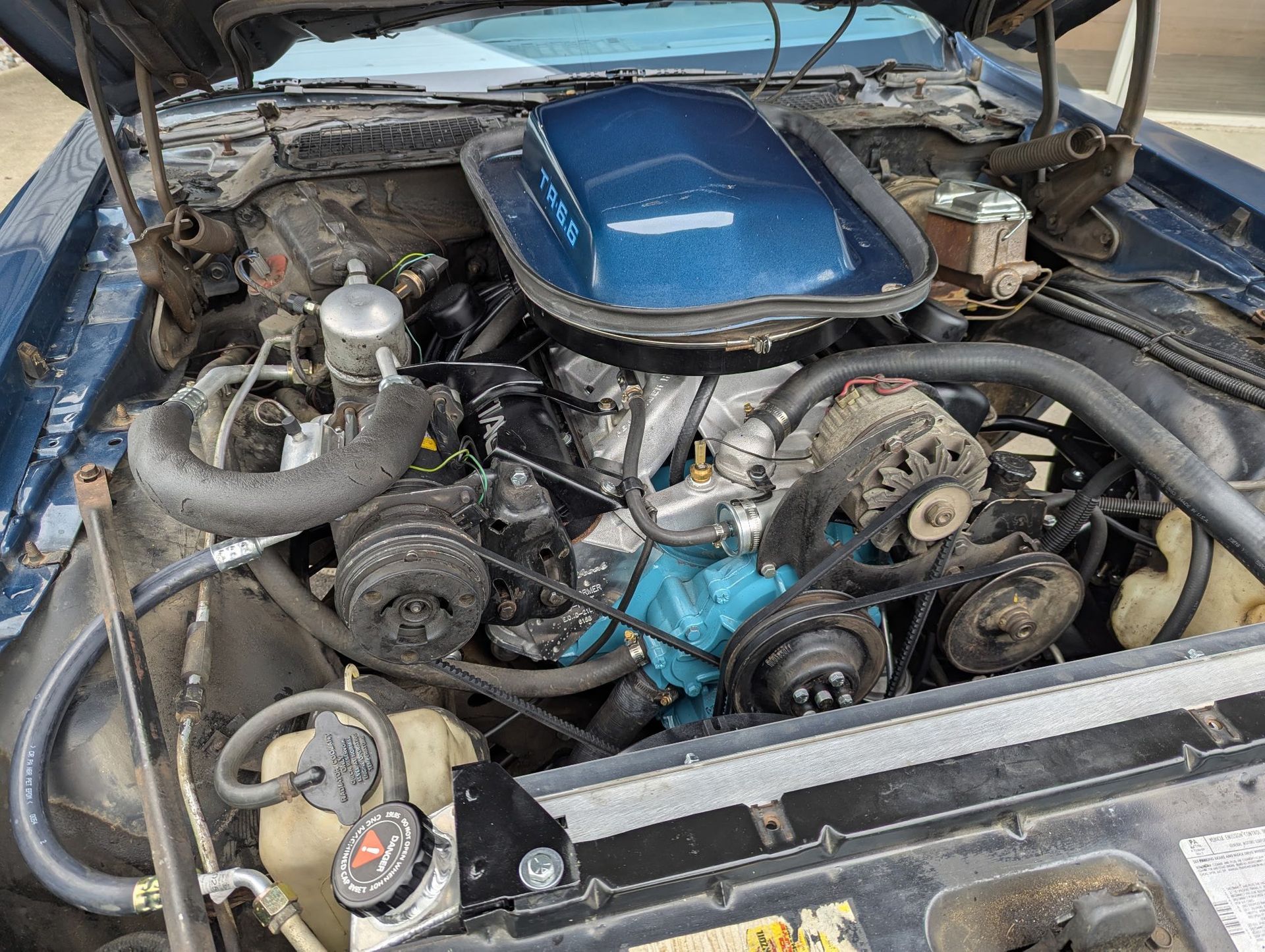 Blue Pontiac Firebird engine bay with a large air cleaner.