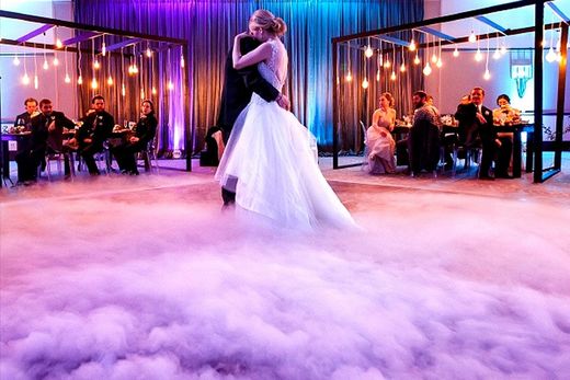 NEWLY WED COUPLE HOLDS CANON LIKE ITEMS SPEWING VIBRANT COLORS. 