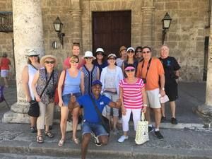 A group of people are posing for a picture in front of a building.
