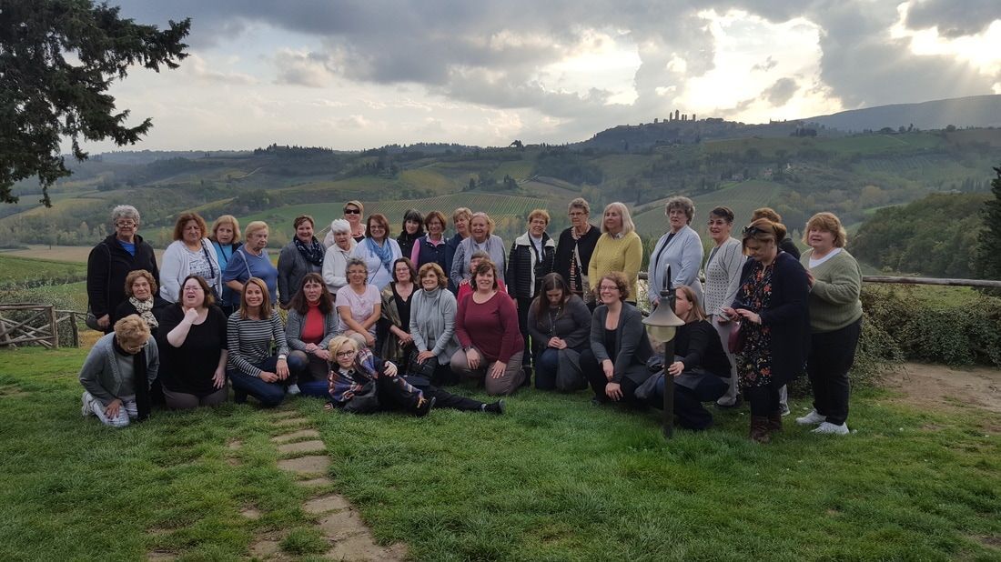 A large group of people are posing for a picture in a field.