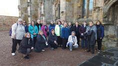 A group of women are posing for a picture in front of a building.