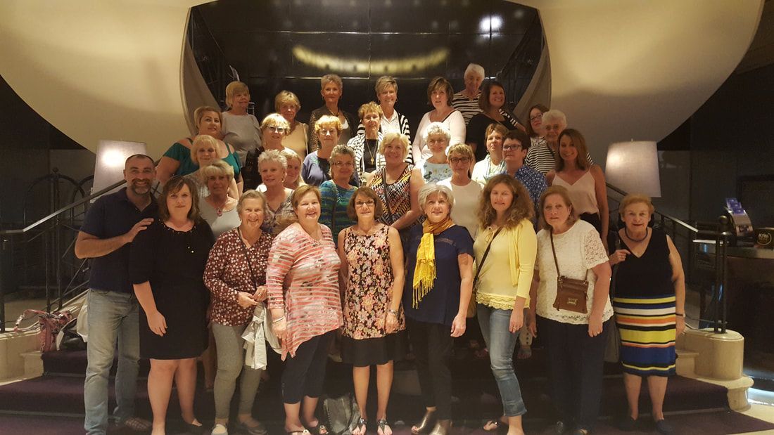A group of people are posing for a picture in front of a building.